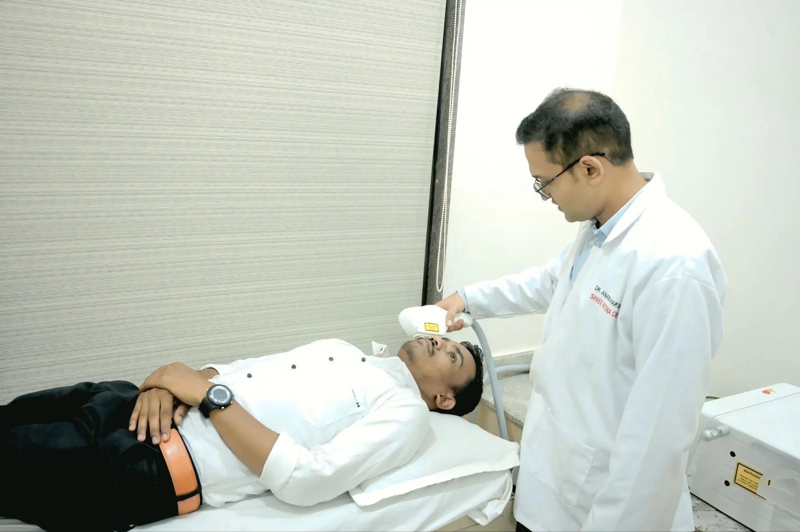 A clinician providing eye care to a reclining patient